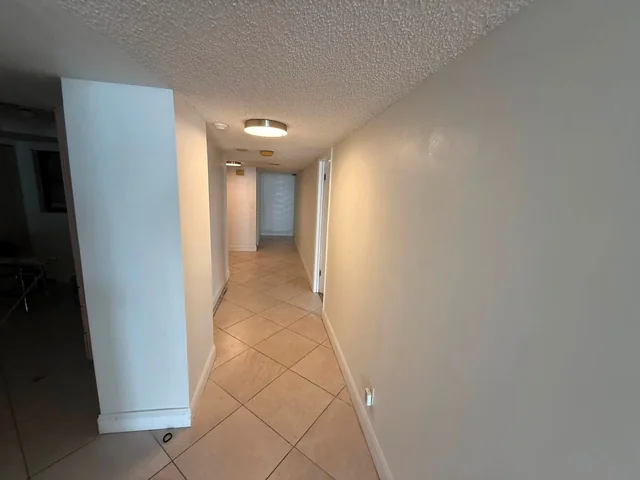 Painted hallway with light walls, door trim and tile flooring