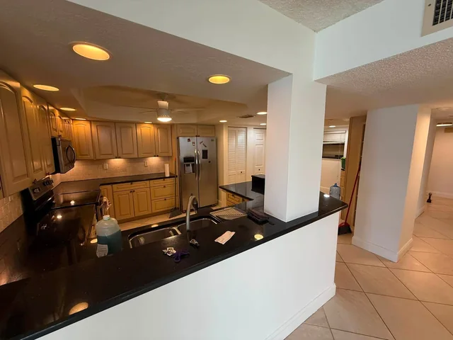 Open-plan kitchen and living area with neutral painted walls and columns